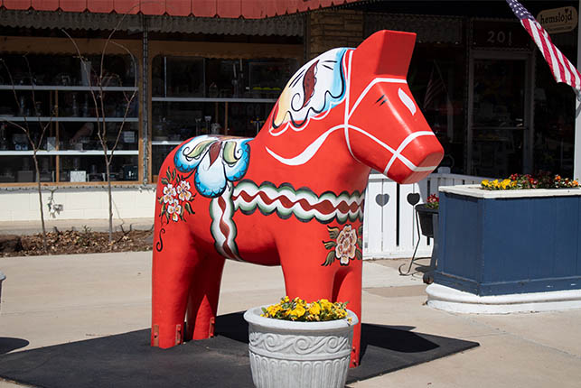 A large red Dala horse outside of the Hemslöjd store